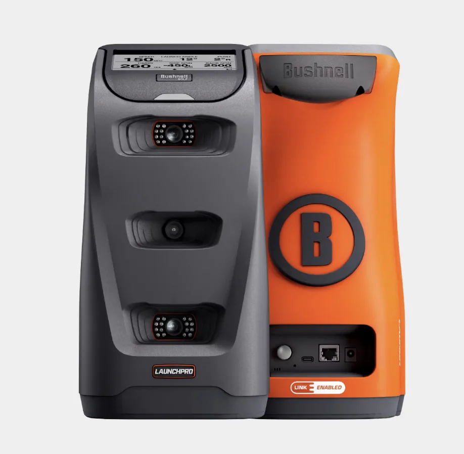 Bushnell Launch Pro von vorne und hinten — links die graue Front mit dem Drei-Kamera-Infrarot-System und dem Datendisplay, rechts das orange Gehäuse mit Anschlüssen und „Link Enabled"-Logo