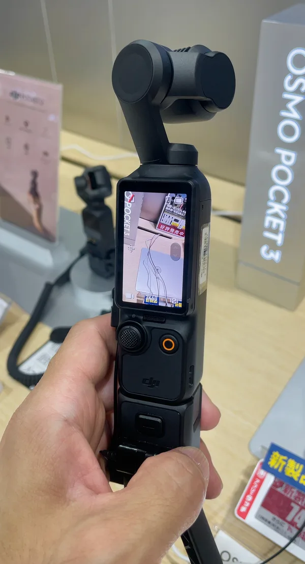 DJI Osmo Pocket 3 — kompakte Gimbal-Kamera mit hochkant stehendem Touchscreen, aufgeklappt und betriebsbereit